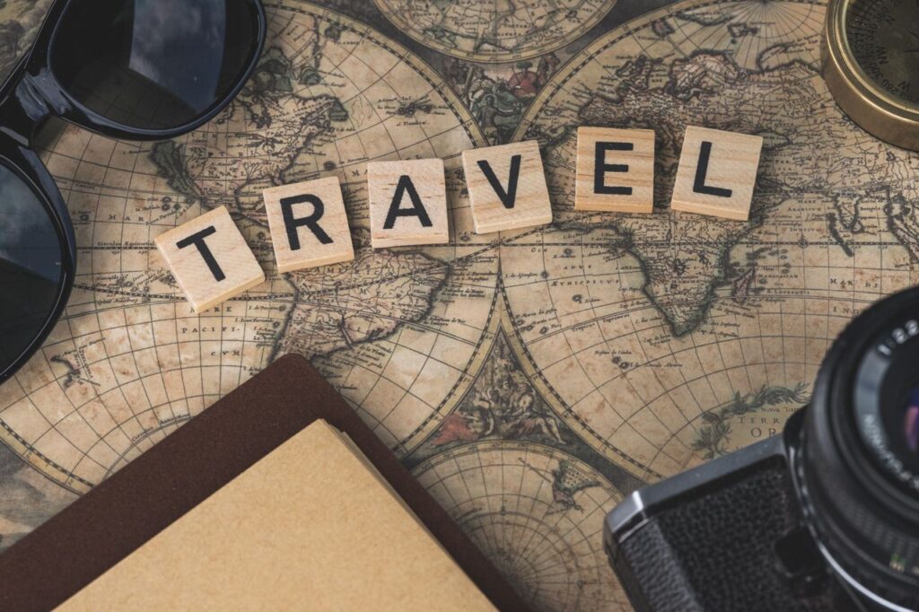 Home : SRL Tours & Travel - Travel The World With Our Eyes Vintage map with travel essentials like camera and sunglasses arranged in a flat lay, perfect for adventure themes.